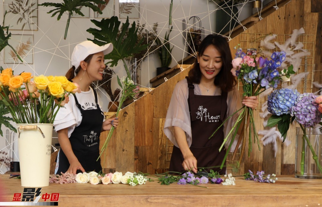 “昆明是鮮花的原產(chǎn)地，有亞洲最大的鮮切花交易市場，可以說具備開花店的天時地利；另外和很多女孩一樣，我從小也就有開花店的夢想！”說起當初的決定，王黎媛說一是因為夢想，另外也跟昆明這個城市產(chǎn)花、賣花的“基因”有關。圖為王黎媛和同事在制作花束。新華網(wǎng) 周亞平/攝 念新洪/文